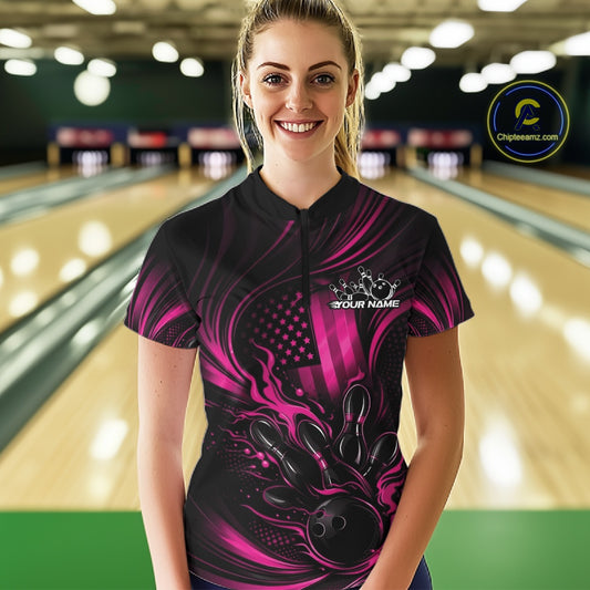 Female model wearing a black and pink bowling quarter-zip shirt at a bowling lane with fiery bowling action artwork and patriotic accents.