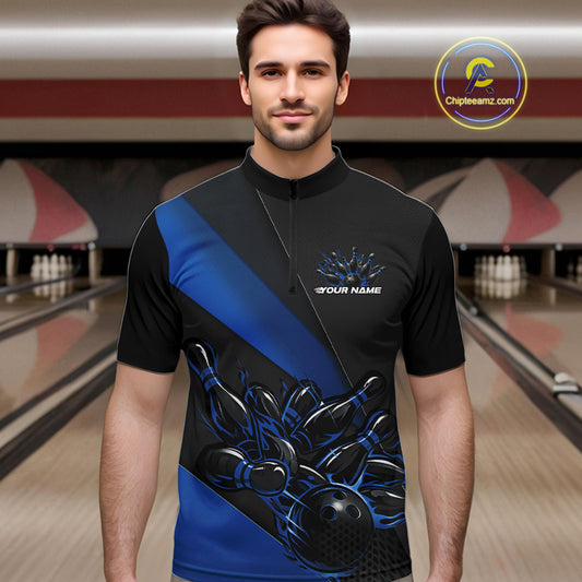Male model front view inside a bowling center wearing a black and blue quarter zip shirt, featuring a flaming bowling ball knocking down pins in vivid motion graphics.