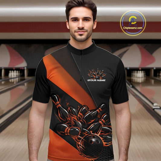 Male model in a bowling venue front view wearing a black and orange quarter zip shirt with a fiery bowling ball hitting pins in energetic bowling action artwork.