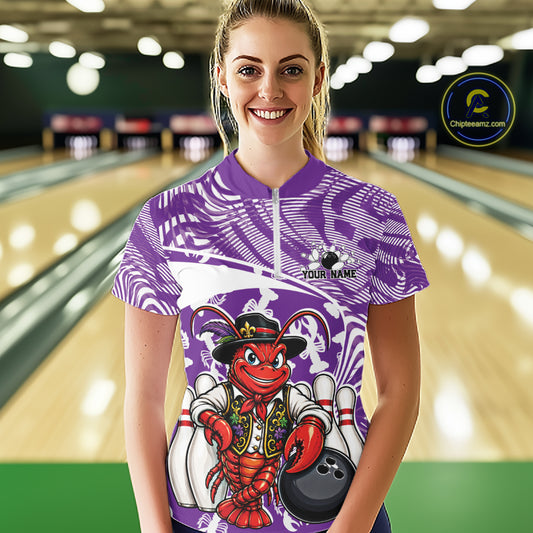 Front view of a happy female model in a bowling alley wearing a purple custom quarter-zip bowling shirt with a funny Cajun crawfish leaning on a bowling ball and a swamp-inspired texture background.