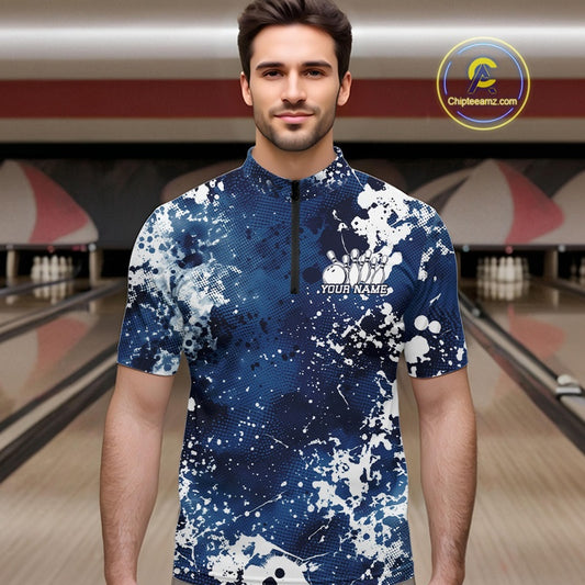 Man wearing a blue and white patterned shirt with a bowling alley in the background