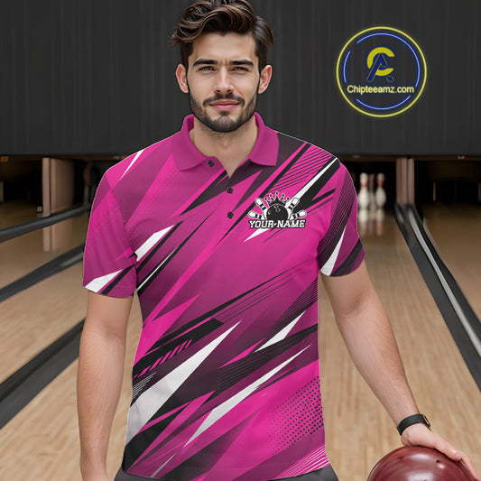 Man wearing a pink and black bowling shirt with a logo in a bowling alley.
