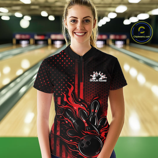 Female model wearing a black and red bowling quarter-zip shirt at a bowling lane with fiery bowling action artwork and patriotic graphics.