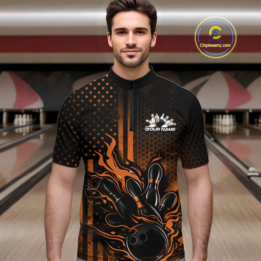 Male model at a bowling lane wearing a black and orange bowling quarter-zip shirt with fiery bowling strike graphics and patriotic styling.