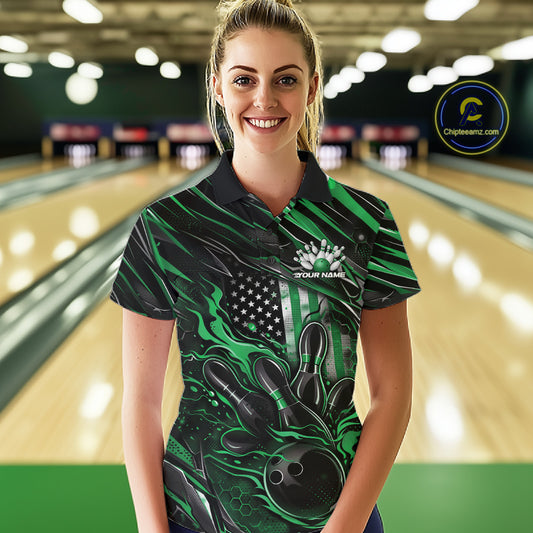 Female model at a bowling lane wearing a black and green bowling polo shirt with patriotic bowling strike artwork and flag-inspired graphics.
