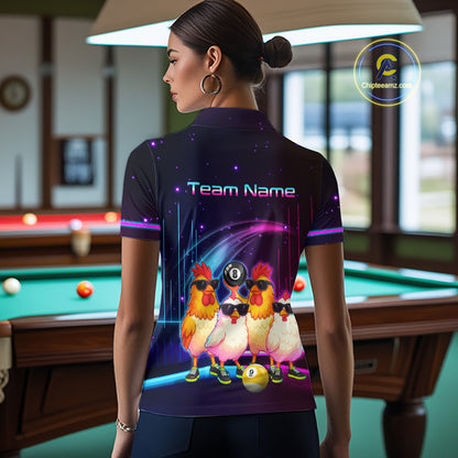 A woman stands in a billiards room wearing a custom short-sleeve polo shirt. The back of the shirt features a dark purple and black space-themed graphic with three cartoon chickens wearing sunglasses and a black 8-ball on their necks, along with the text 'Team Name'.