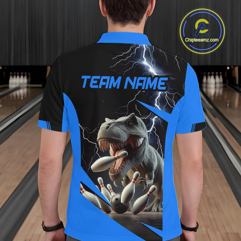 A man viewed from behind wearing a custom bowling shirt with a blue and black design, featuring a graphic of a T-Rex biting bowling pins under lightning, with 'TEAM NAME' printed on the back. The background shows bowling lanes