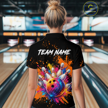 A woman viewed from behind wearing a black short-sleeve polo shirt with a colorful bowling-themed graphic on the back. The design features the text 'TEAM NAME' in white above a multicolor bowling ball and pins motif, set against a blurred bowling alley background.