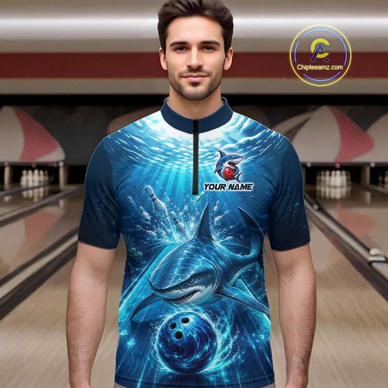 Man wearing a blue and black bowling shirt with shark design in a bowling alley.