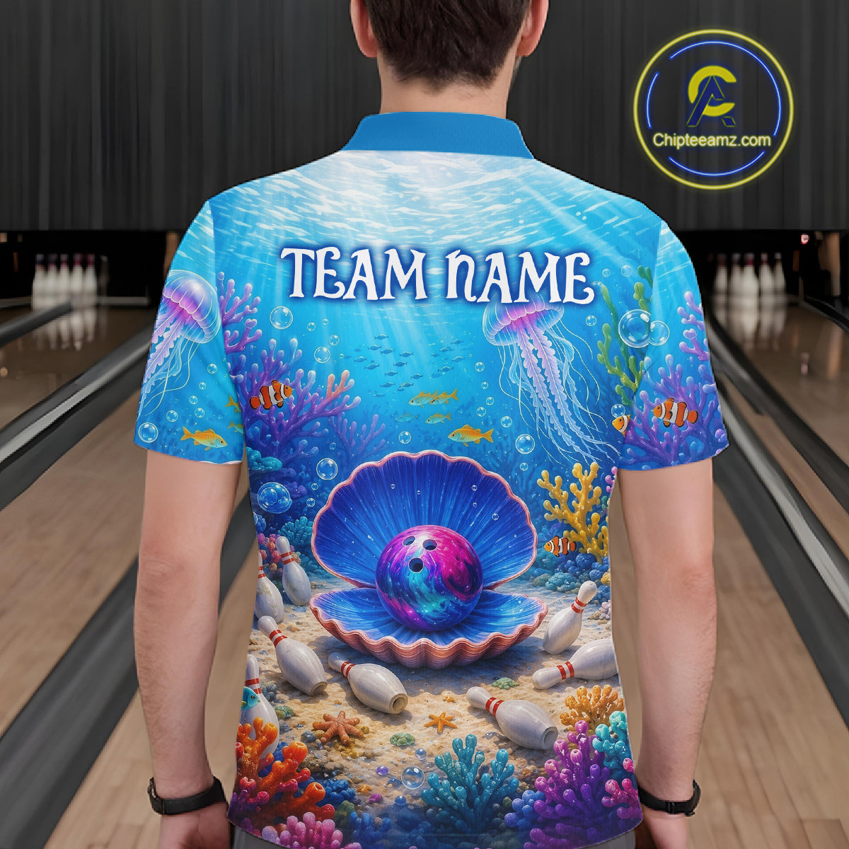 Person wearing a colorful bowling shirt with an underwater design and 'TEAM NAME' text on a bowling alley.