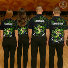 Load image into Gallery viewer, Four people standing with their backs to the camera in a bowling alley, wearing matching black bowling shirts with a green dinosaur graphic and the text 'TEAM NAME' on the back. 