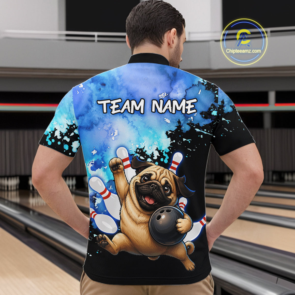 A man viewed from behind wearing a custom bowling-themed short-sleeve shirt with a cartoon pug holding a bowling ball on the back, set against a bowling alley background. 