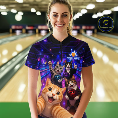 Person wearing a colorful bowling shirt with cat designs in a bowling alley.