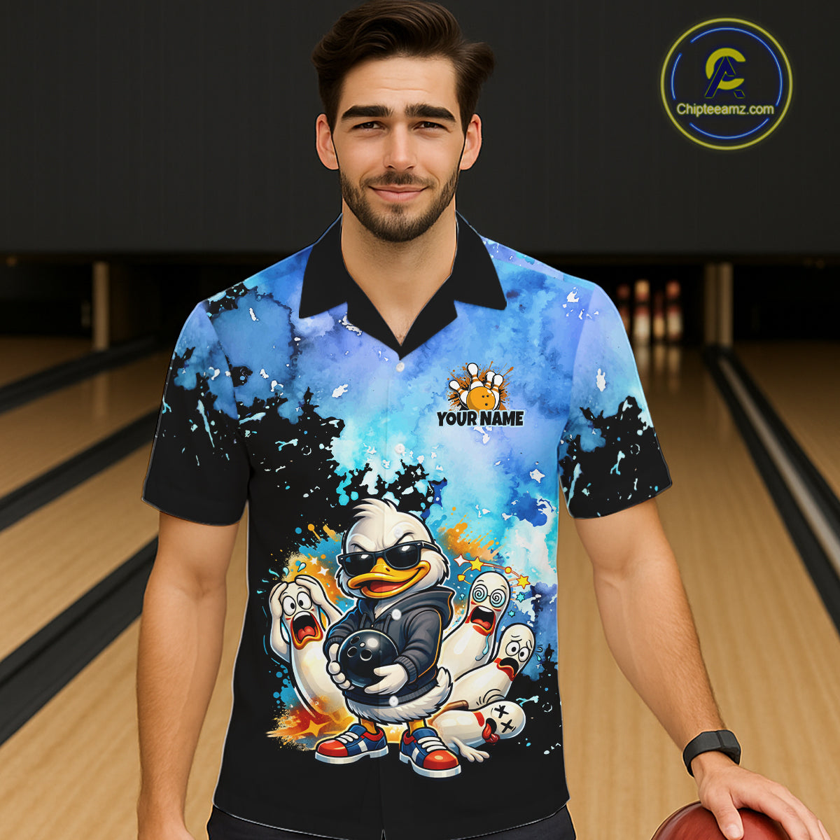 Person wearing a colorful bowling-themed shirt with cartoon characters in a bowling alley.