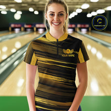 Load image into Gallery viewer, Female model wearing a custom black gold bowling quarter-zip shirt front view featuring a gold bowling ball emblem, dynamic gold brush stroke pattern and striped design at the bowling alley