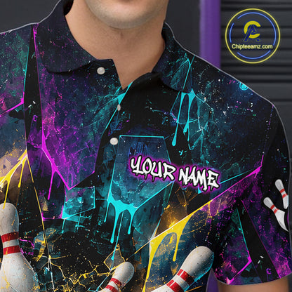 A close-up of a person wearing a short-sleeve polo shirt with a colorful bowling-themed graphic print. The shirt features a black base with neon paint-drip splashes in purple, blue, yellow, and pink, bowling pins at the bottom corners, and the text 'YOUR NAME' printed on the chest.