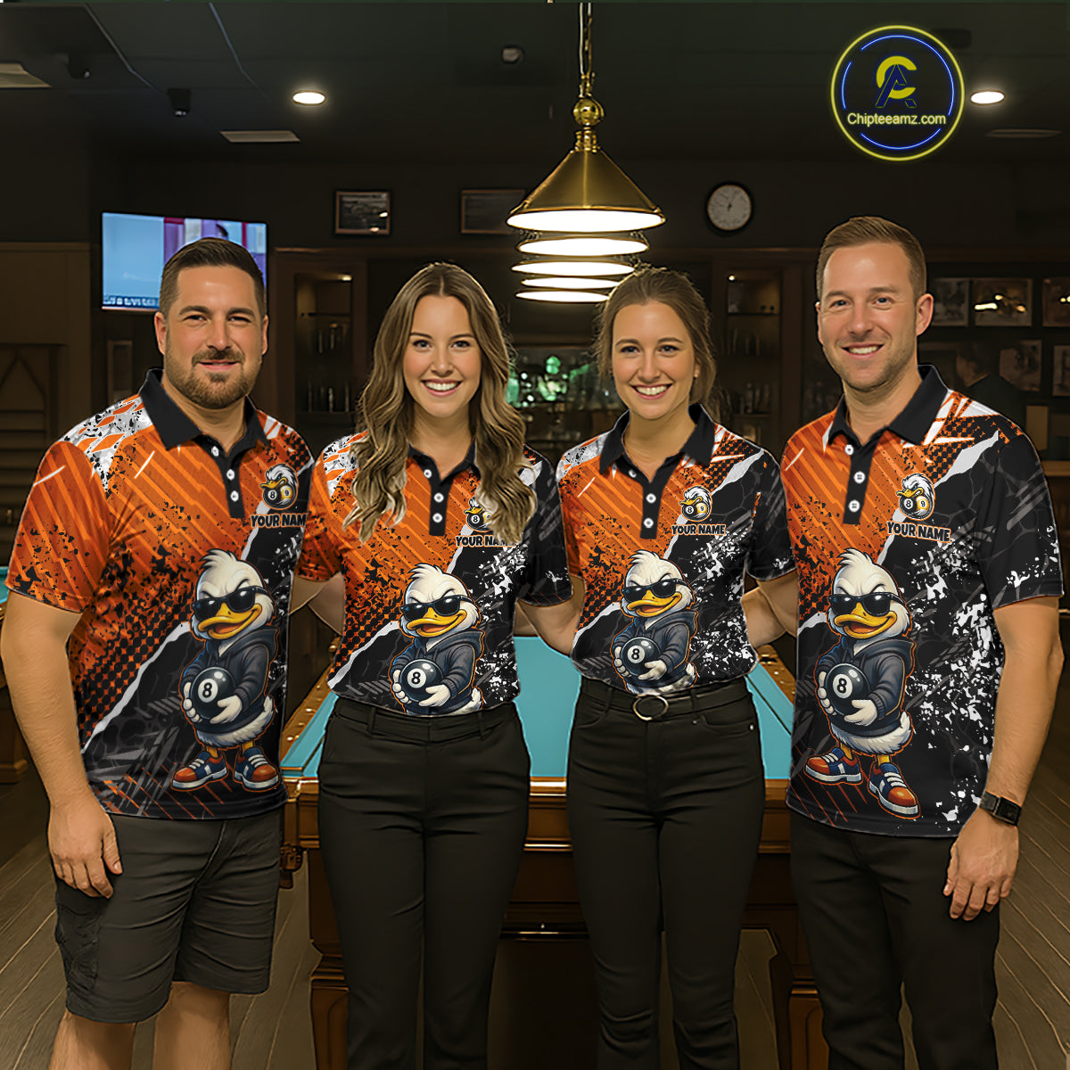 Four people standing together in an indoor pool hall setting, wearing matching custom-printed polo billiard shirts with a cartoon duck graphic and orange/black patterns