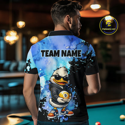 A man viewed from behind wearing a custom-printed polo shirt with a blue and black watercolor design, a cartoon duck character holding a billiard ball, and the text 'TEAM NAME' on the back. The shirt is shown in a pool hall setting with a green pool table in the background.