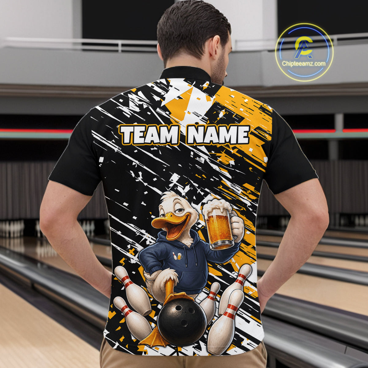 A man viewed from behind wearing a custom bowling-themed short-sleeve shirt with a large graphic of a cartoon duck holding a bowling ball and pins, with 'TEAM NAME' printed across the back. The shirt features a black, white, and yellow paint-splatter design.