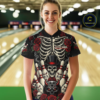 A woman standing in a bowling alley wearing a black short-sleeve bowling shirt with a detailed skeleton and skull graphic featuring red roses and bowling pins. The shirt has 'YOUR NAME' printed on the chest.