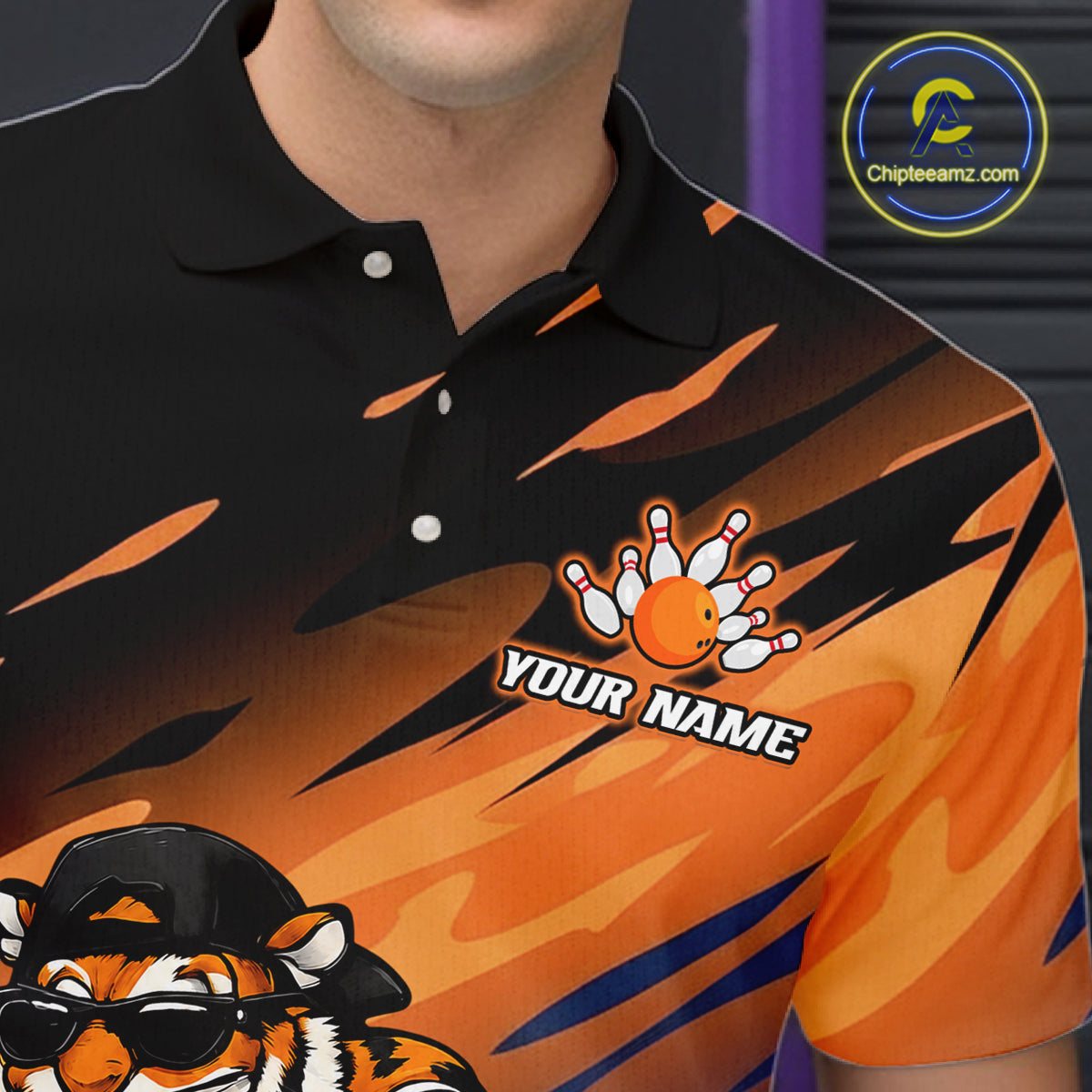 A close-up of a man wearing a custom black and orange polo shirt with a tiger graphic and bowling theme. The shirt features a black and orange flame pattern, a custom bowling hand graphic with the text 'YOUR NAME', and a cartoon tiger wearing sunglasses.