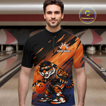 A man wearing a custom short-sleeve bowling jersey with a black and orange graphic design featuring a cartoon tiger mascot and the text 'YOUR NAME'. The background shows a blurred bowling alley.