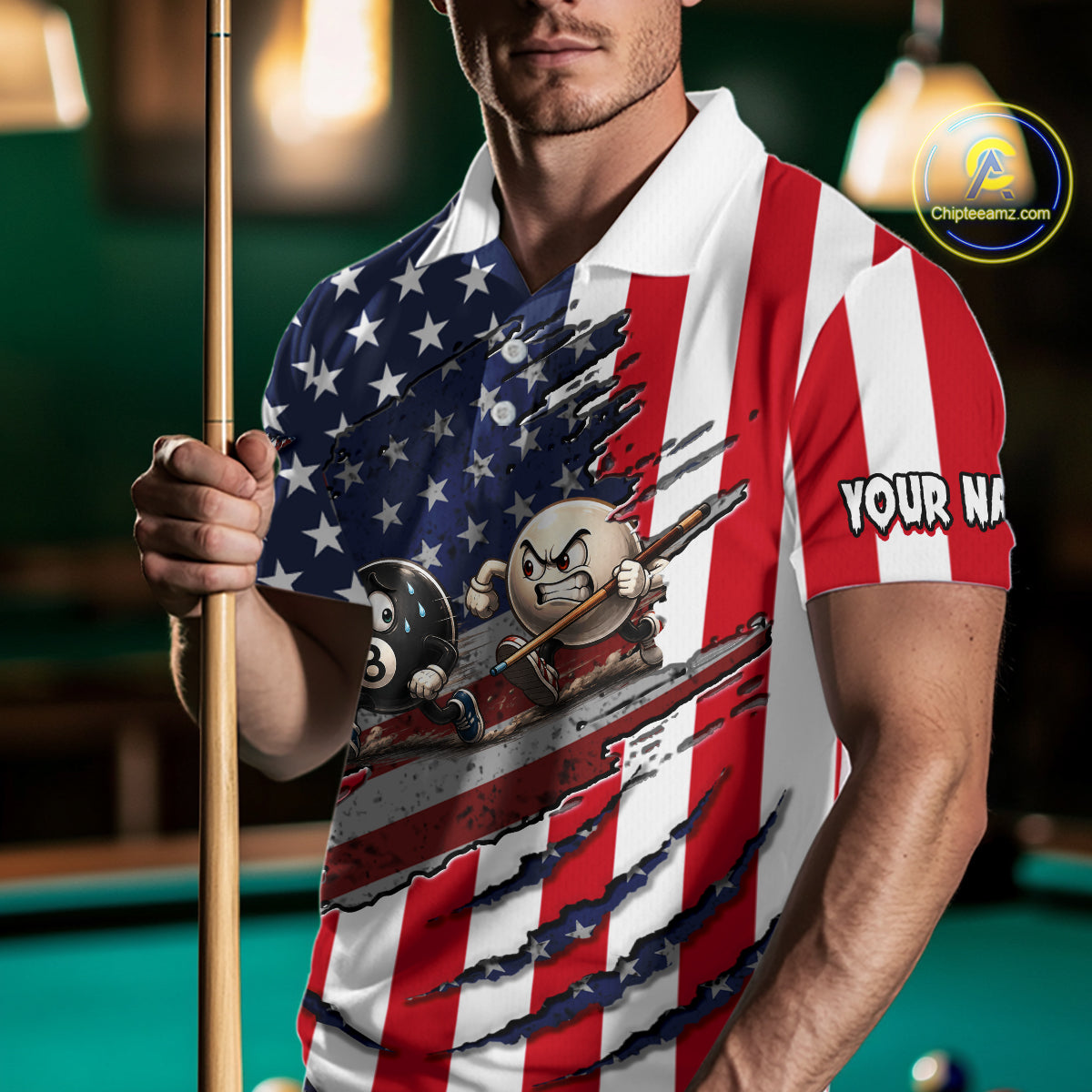 A man wearing a custom polo shirt with a patriotic American flag design and a 3D-effect torn graphic showing billiards balls and cues. He is holding a pool cue in a dimly lit pool hall environment.