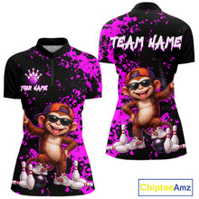Load image into Gallery viewer, Front and back views of a women's short-sleeve polo shirt with a black base, bright purple paint splatter pattern, and a cartoon monkey graphic wearing sunglasses and an orange cap, surrounded by bowling pins and balls. The front shows 'YOUR NAME' and a bowling pin icon, and the back shows 'TEAM NAME' in white.