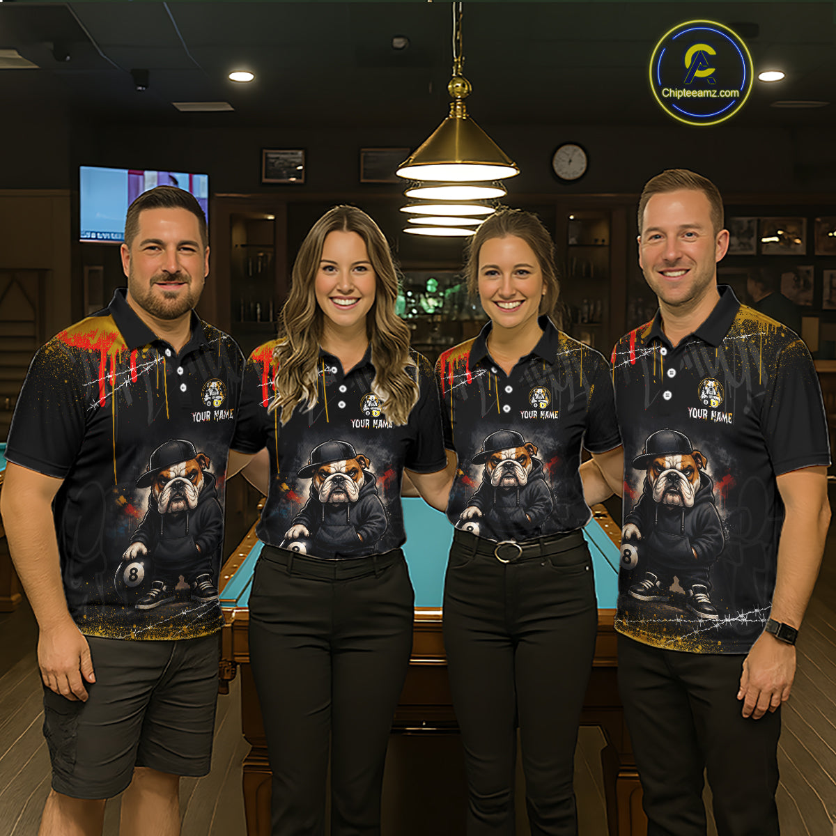 Four people standing together in a dimly lit bar or lounge, wearing matching dark polo shirts with a large printed bulldog graphic and the text 'YOUR NAME'. 