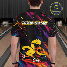 Load image into Gallery viewer, A person viewed from behind wearing a black short-sleeve custom bowling shirt with a colorful paint-splatter design, a yellow cartoon duck wearing sunglasses, and the text 'TEAM NAME' across the back. The background shows bowling lanes in a dimly lit bowling alley.