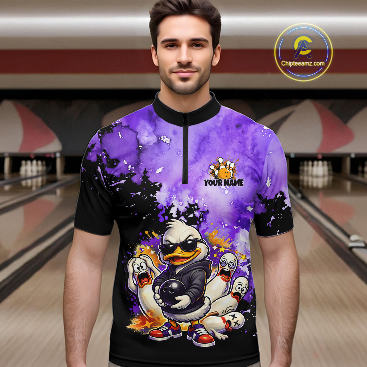 A man wearing a custom short-sleeve bowling jersey with a purple and black watercolor splatter design, featuring a cartoon duck character and the text 'YOUR NAME' on the front. The background shows blurred bowling lanes.