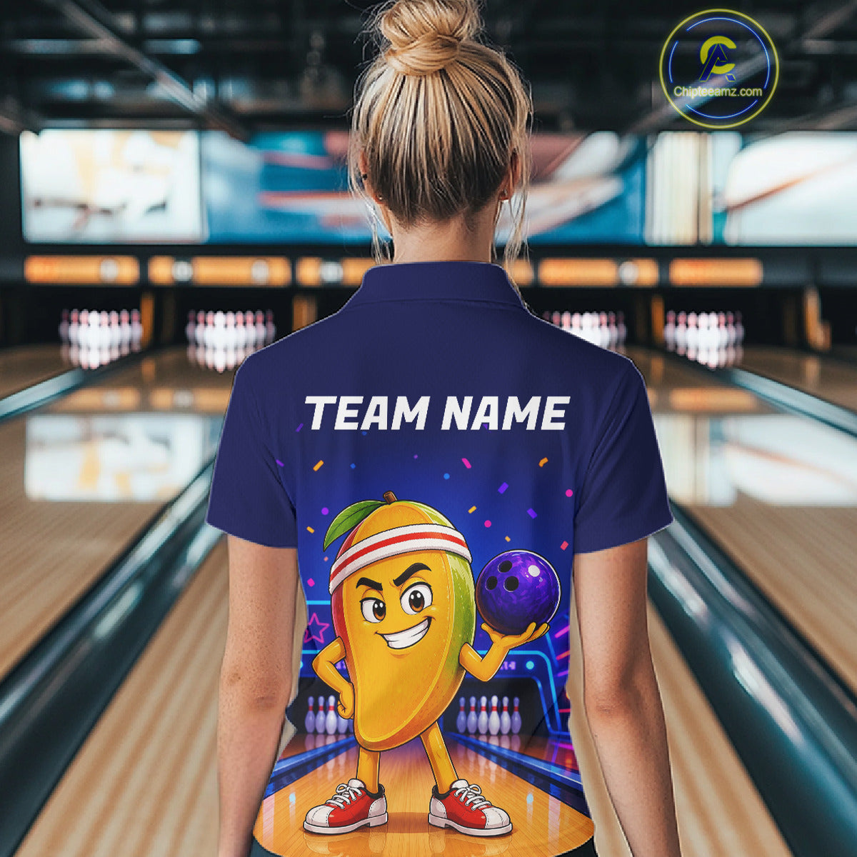 Person wearing a blue shirt with a cartoon character and 'TEAM NAME' text in a bowling alley.
