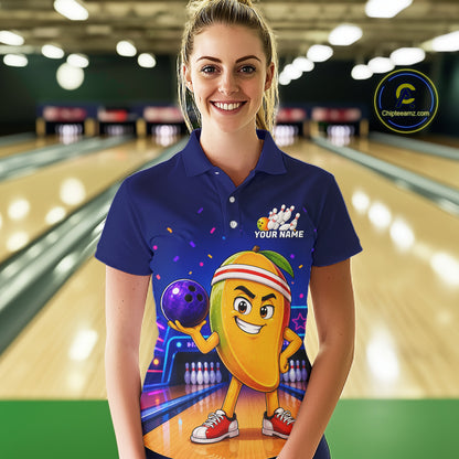 Woman wearing a blue bowling-themed shirt with a cartoon character in a bowling alley.