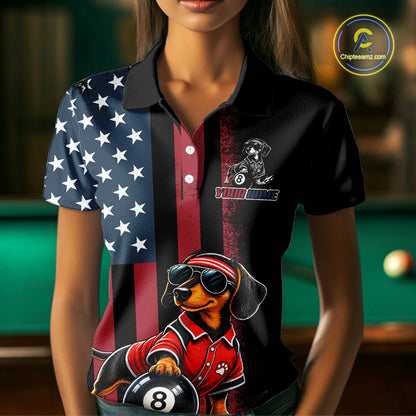 A woman wearing a short-sleeve polo shirt with a patriotic American flag design on the left side and a red vertical stripe on the right. The shirt features a graphic of a dachshund wearing sunglasses and a red polo shirt while holding an 8-ball