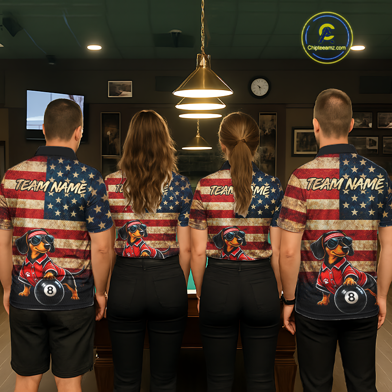 Four people standing with their backs to the camera in a billiards room, wearing matching custom team shirts with a distressed American flag design and a cartoon dog wearing sunglasses 