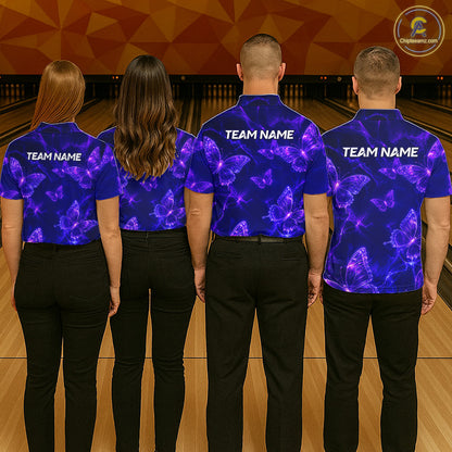 Four people standing in a bowling alley, viewed from behind, wearing matching royal blue short-sleeve bowling shirts with a purple neon butterfly pattern and white 'TEAM NAME' text on the back.