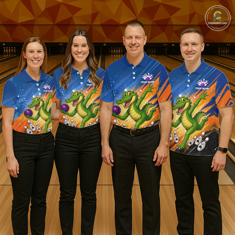 Four people standing in a bowling alley wearing matching blue bowling shirts with a colorful green alligator graphic and black pants. The shirts have a blue gradient background with stars and orange side panels.