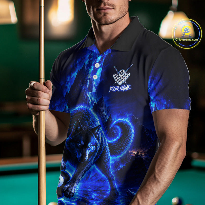 A man wearing a custom short-sleeve polo shirt with a blue wolf graphic print, holding a pool cue in a dimly lit pool hall. The shirt features a black collar and shoulders, transitioning into a vibrant blue and black wolf design with a white logo and 'YOUR NAME' text on the chest.