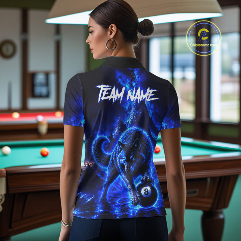 A woman stands in a billiards room wearing a short-sleeve polo shirt from the back. The shirt features a dramatic blue and black graphic print of a wolf and an 8-ball, with 'TEAM NAME' printed in white across the upper back.