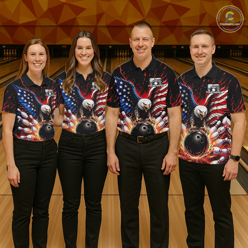 Four people wearing matching bowling shirts with eagle and ball designs on a bowling alley.
