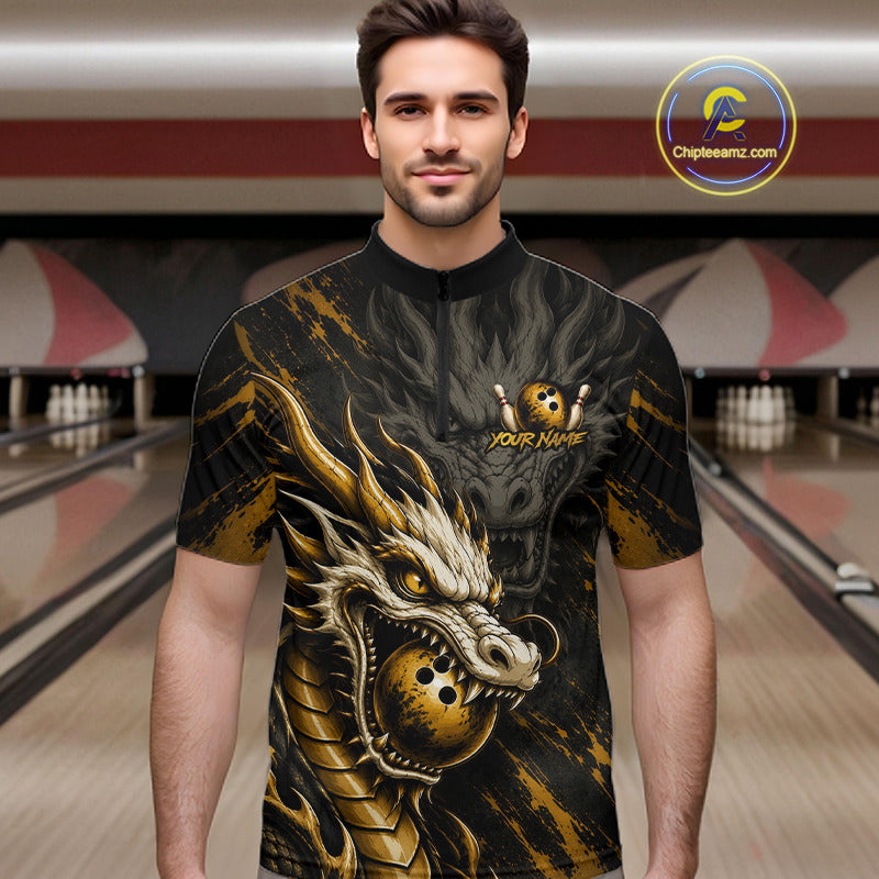 A man wearing a short-sleeve bowling shirt with a large gold and black dragon graphic, standing in a bowling alley. The shirt features a mock neck, a short zipper, and a customizable chest graphic with a skull and crossed bowling pins.