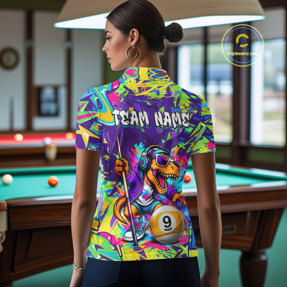 Person wearing graffiti shirt with a dinosaur design in a pool hall.