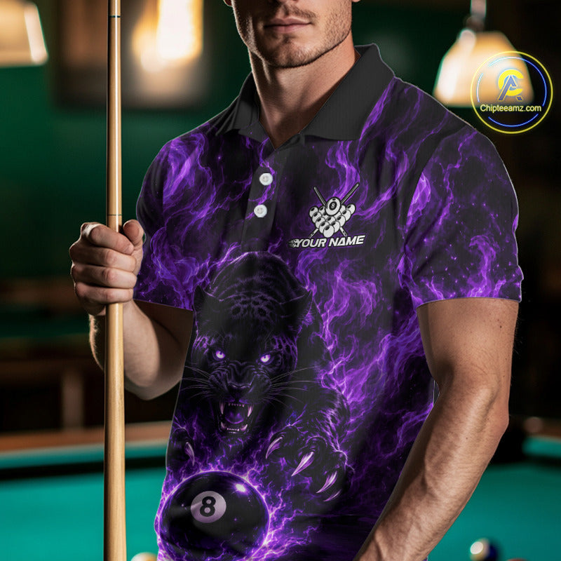 A man wearing a black and purple short-sleeve polo shirt with a glowing purple panther and billiard ball graphic, holding a pool cue in a dimly lit billiards room. 