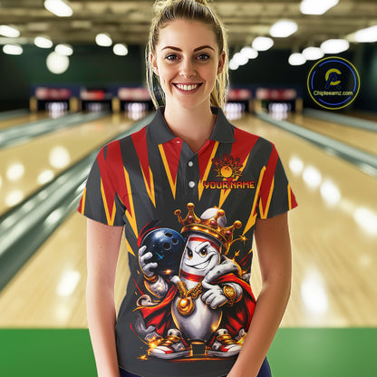 Woman wearing a colorful bowling shirt with a character design in a bowling alley.