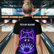 Load image into Gallery viewer, A woman viewed from behind wearing a black short-sleeve polo shirt with a large colorful raccoon graphic and the text 'TEAM NAME' on the back, standing in a bowling alley.