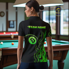 Load image into Gallery viewer, Women wearing billiards polo shirt featuring an eight ball design surrounded by flowing green flame graphics on a black background.