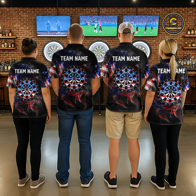 Man wearing a black darts polo featuring patriotic American flag smoke graphics, dartboards, blue darts, and custom team and player name text.