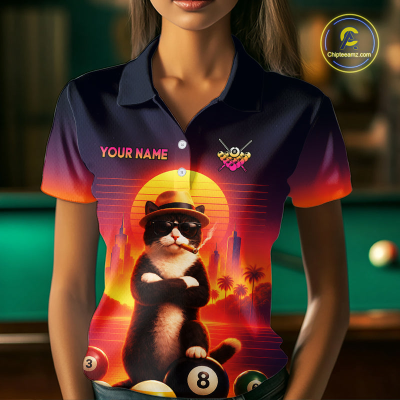 A woman wearing a custom short-sleeve polo shirt with a colorful graphic of a cat wearing sunglasses and a hat, sitting on billiard balls in front of a sunset. The shirt has a dark navy blue base with a red and orange gradient on the sleeves and collar, and the text 'YOUR NAME' on the chest.