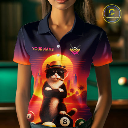 A woman wearing a custom short-sleeve polo shirt with a colorful graphic of a cat wearing sunglasses and a hat, sitting on billiard balls in front of a sunset. The shirt has a dark navy blue base with a red and orange gradient on the sleeves and collar, and the text 'YOUR NAME' on the chest.