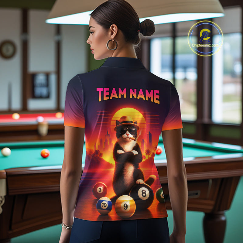 A woman stands in a billiards room wearing a custom-printed short-sleeve polo shirt, viewed from behind. The shirt features a colorful graphic of a cat wearing sunglasses and sitting on billiard balls, with the text 'TEAM NAME' printed above.